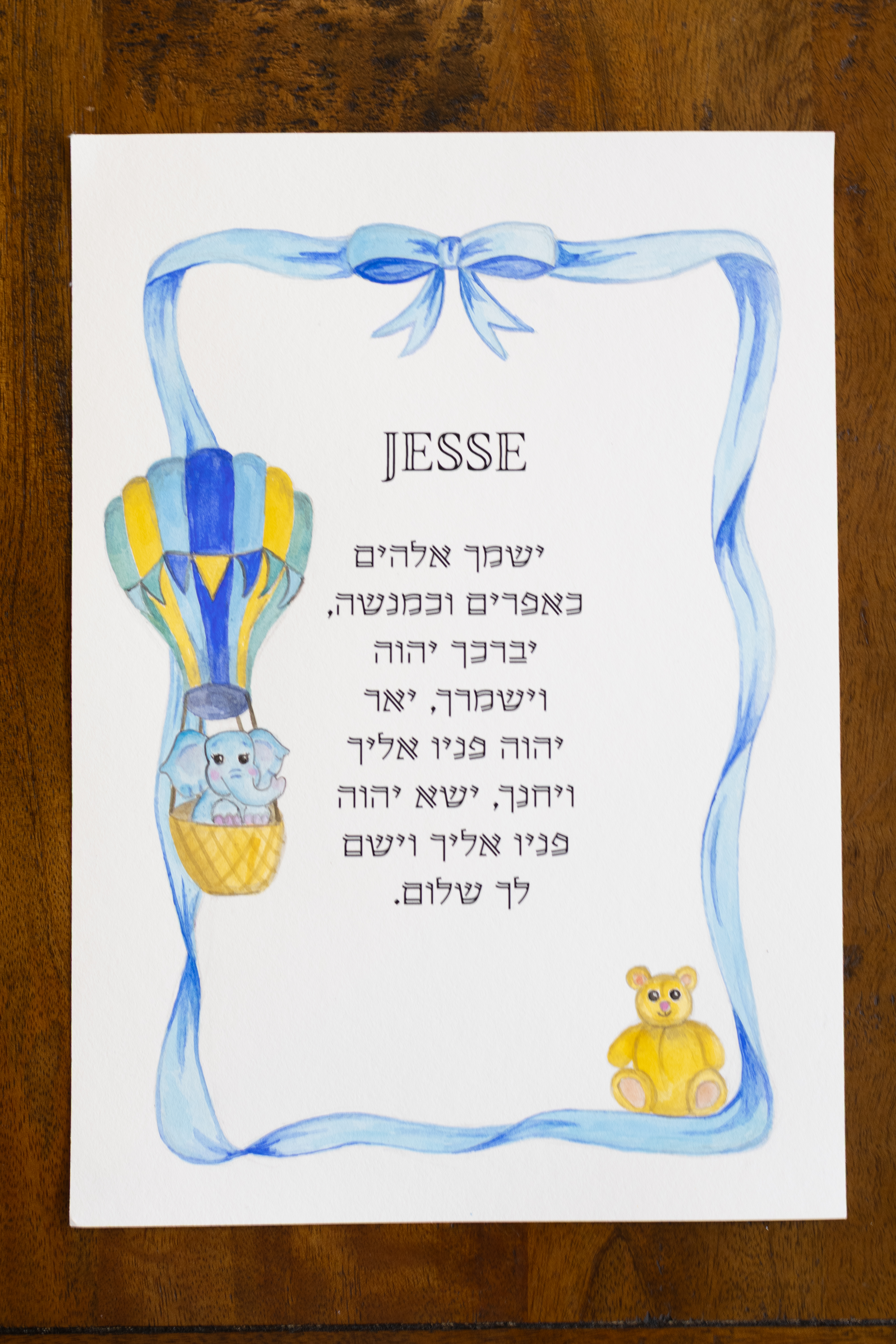 הדפס מוגמר ואישי של ברכת הבנים לילד, מוצג על שולחן עץ