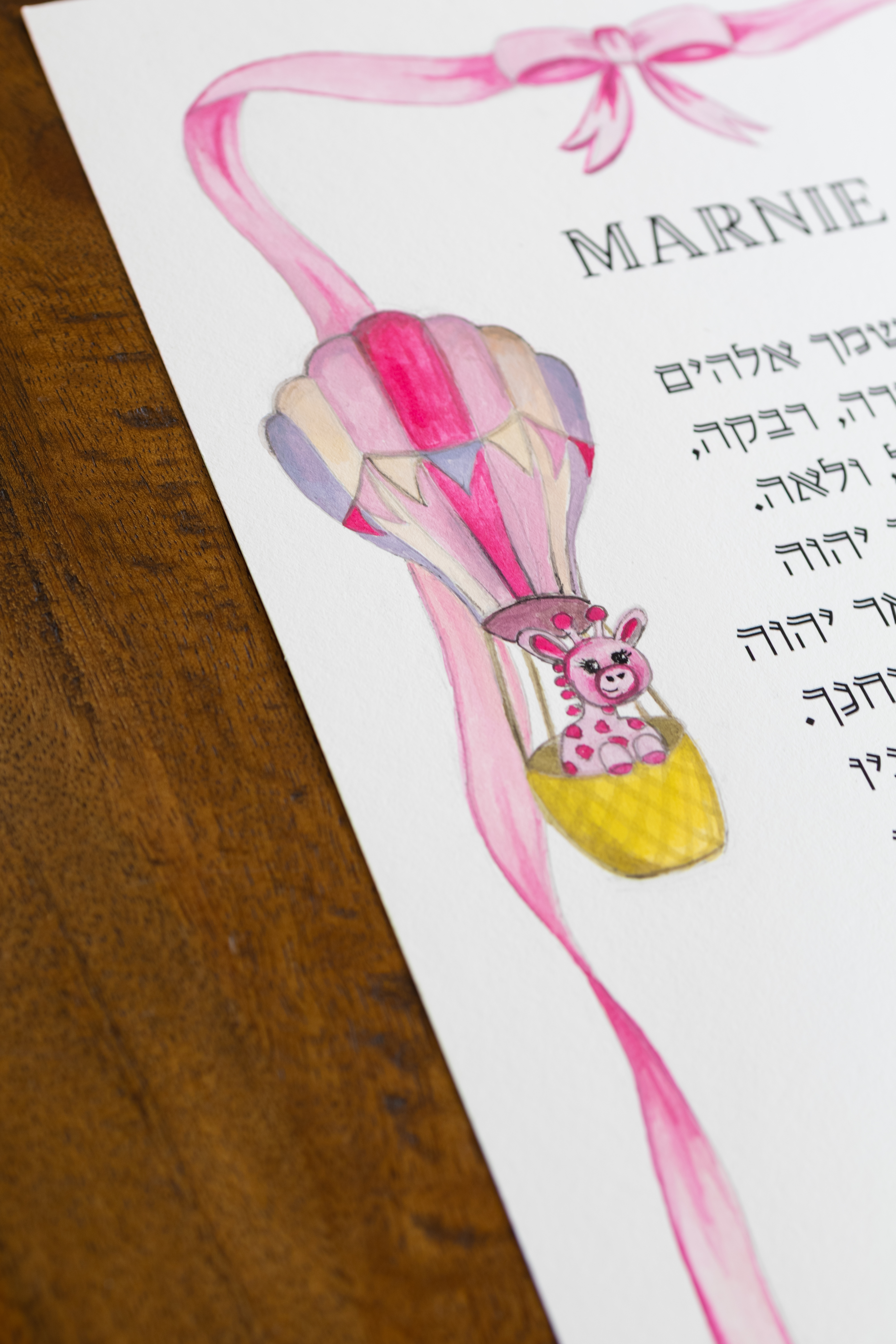 תקריב של הג׳ירפה הקטנה בכדור הפורח בהדפס ברכת הבנות לילדה